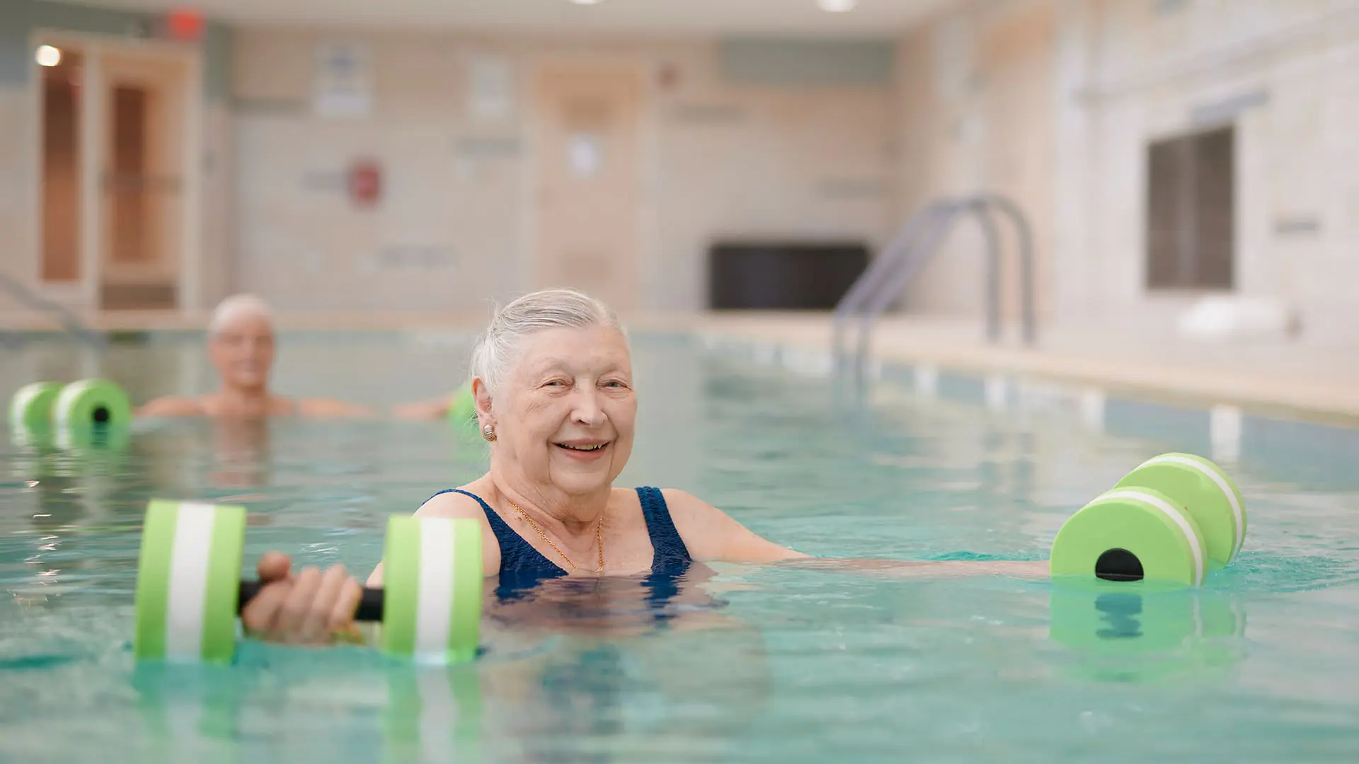senior woman doing water aerobics woman enjoying water sports for seniors in the pool