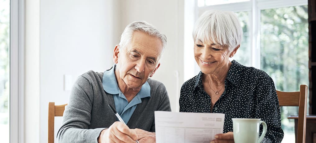 senior couple looking at a cost sheet for a senior living community