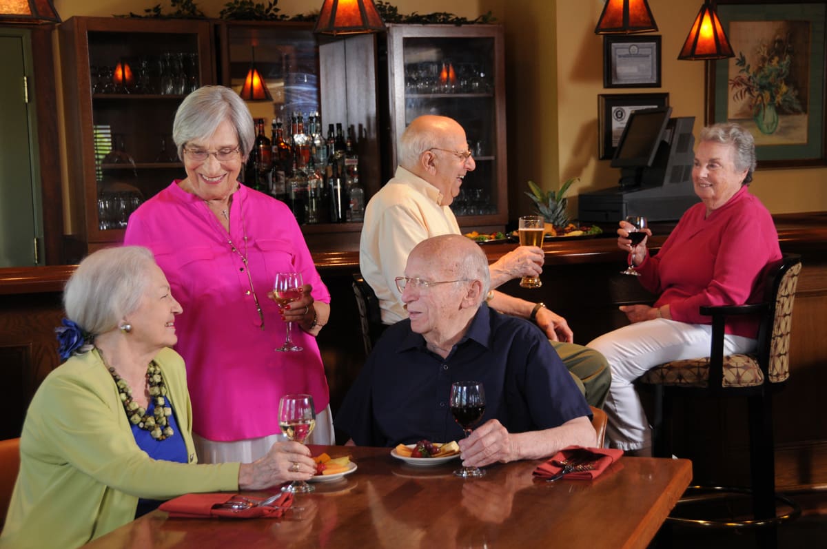 seniors drinking wine and laughing in a restaurant