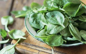bowl of spinach on a table - leafy greens are a heart healthy food